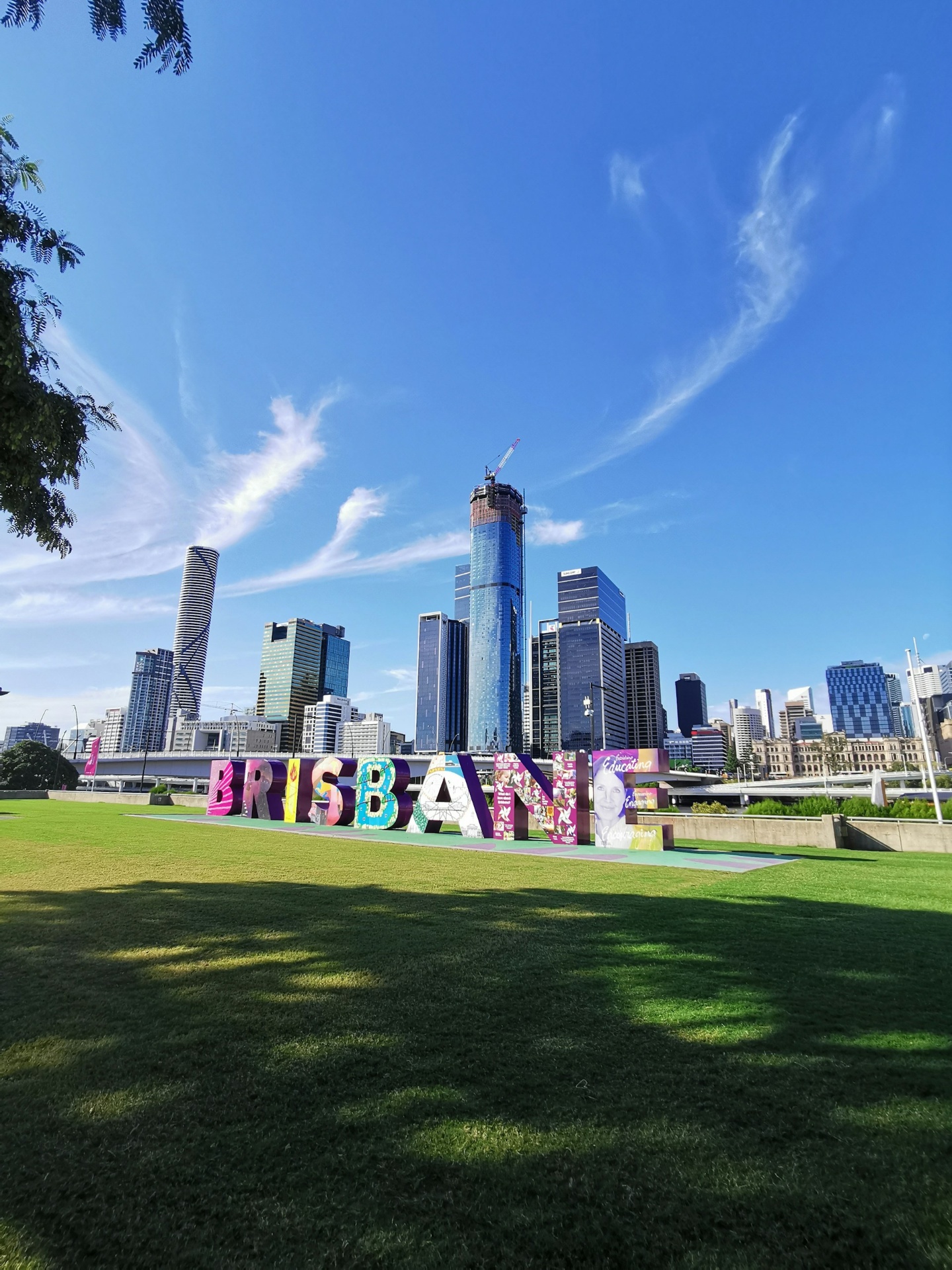 Brisbane city skyline with the Brisbane sign in a sunny riverside park